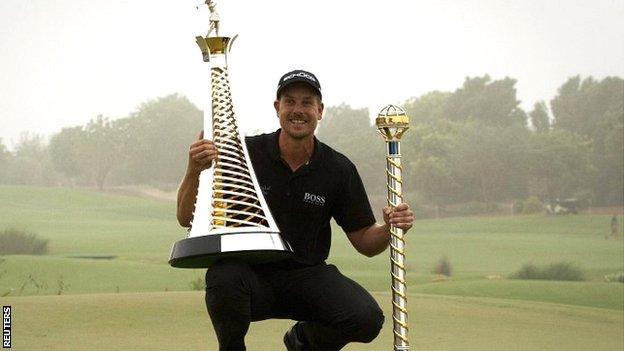 Henrik Stenson with the World Tour Championship and Race to Dubai trophies