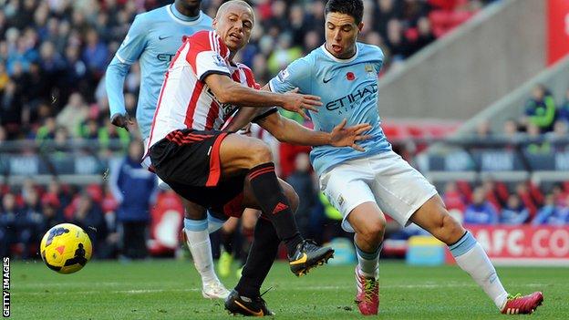 Wes Brown (left) of Sunderland in action with Samir Nasri of Manchester City