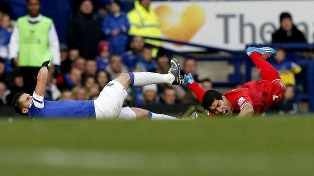Liverpool's Luis Suarez (R) is fouled by Everton's Kevin Mirallas