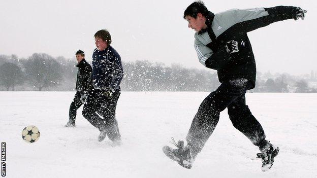 Youngsters play football in the snow