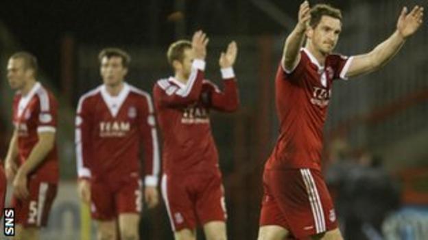 Aberdeen players celebrate at the full-time whistle in front of a crowd of over 9,000