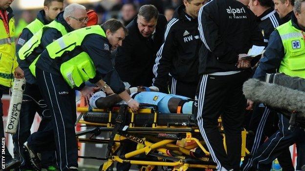 West Ham manager Sam Allardyce (centre) checks on the wellbeing of player Guy Demel who is stretchered off in the match at Cardiff