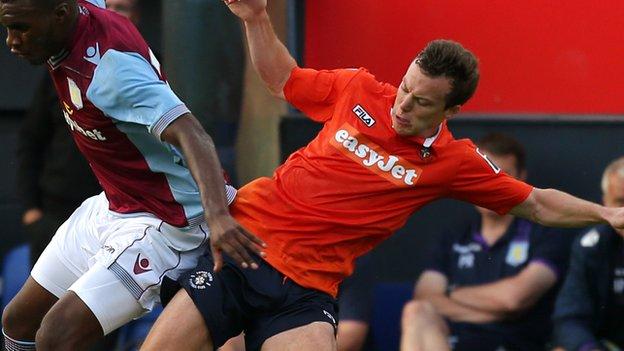 Shaun Whalley tackles Christian Benteke during Luton's pre-season friendly against Aston Villa