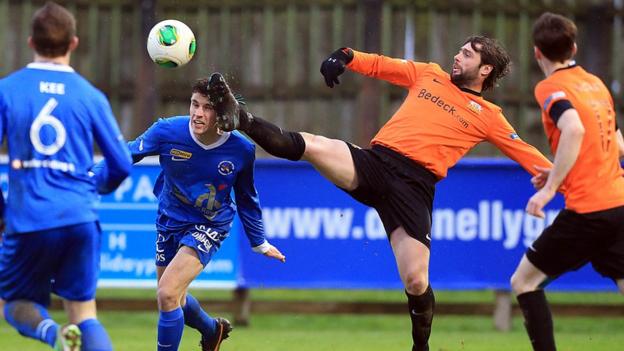 Ballinamallard's Nigel Beacom goes in bravely as Glenavon player-manager Gary Hamilton stretches to reach the ball at Ferney Park