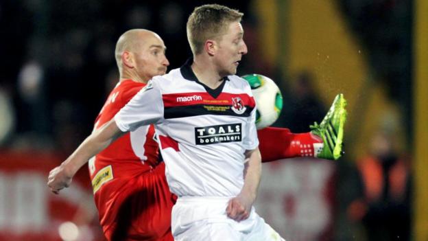 Barry Johnston of Cliftonville competes against Crusaders opponent Chris Morrow during the League Cup final at Solitude