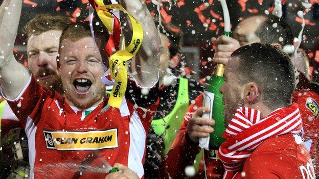 George McMullan lifts the cup after Cliftonville's penalty shot-out win over Crusaders