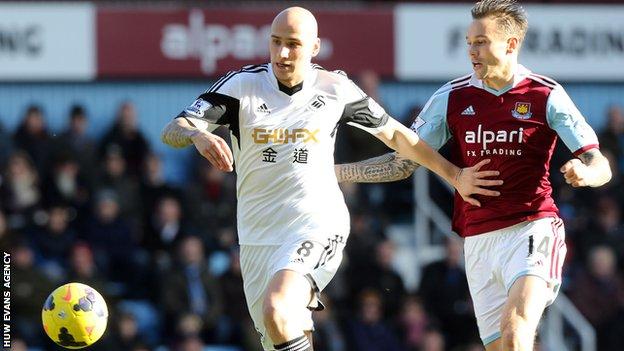 Swansea's Jonjo Shelvey takes on West Ham's Matt Taylor
