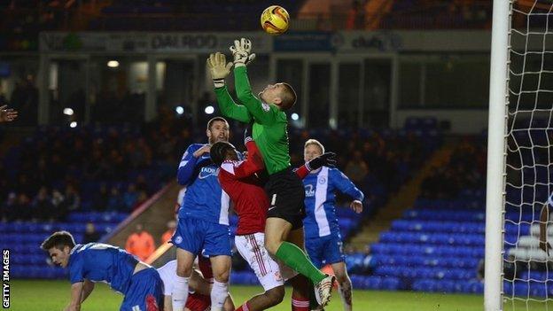 Bobby Olejnik of Peterborough United saves from Nile Ranger of Swindon Town