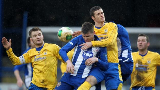 Dungannon duo Ryan Harpur and Gary Liggett in aerial action with Coleraine's Stephen Lowry at Ballycastle Road