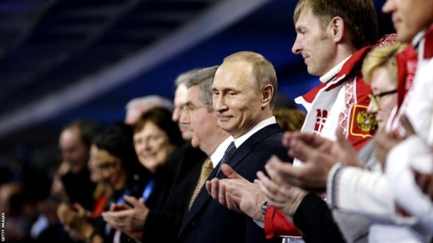 Russian President Vladimir Putin (C) stands during the Closing Ceremony of the Sochi Winter Olympic