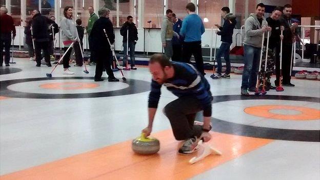 People taking curling lesson