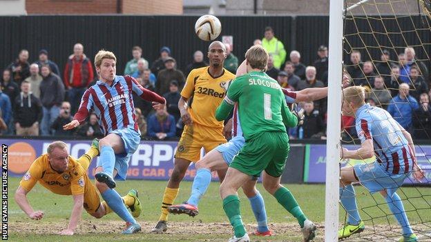 Newport County's Lee Minshull scores against Scunthorpe with a diving header.