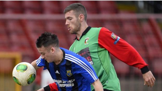 Armagh City's Gareth Grimley shields the ball from Glentoran's Mark Clarke