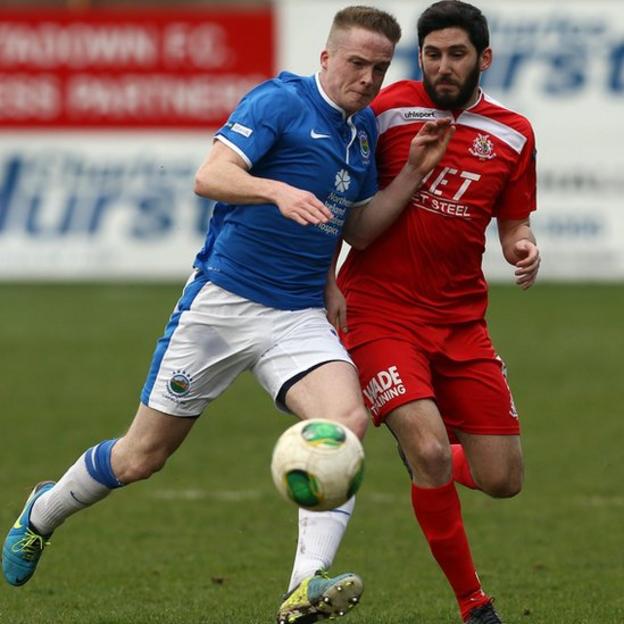 Aaron Burns of Linfield battles for the ball with Sean Mackle of Portadown