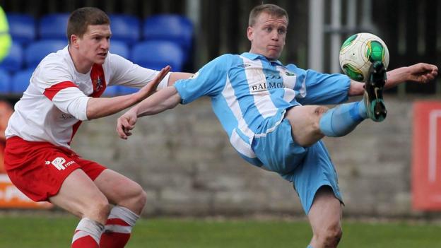 Mark Burns of Ards closes in as Warrenpoint's Liam Bagnall gets the ball away