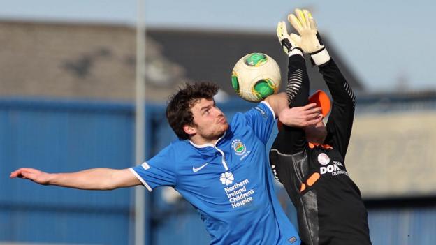 Philip Lowry challenges Gareth Buchanan during the Premiership game at Windsor Park