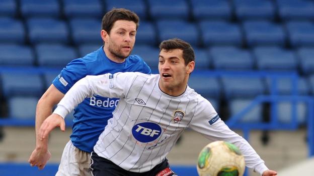 Glenavon defender Eddie McCallion prepares to challenge Coleraine forward David McDaid at Mourneview Park