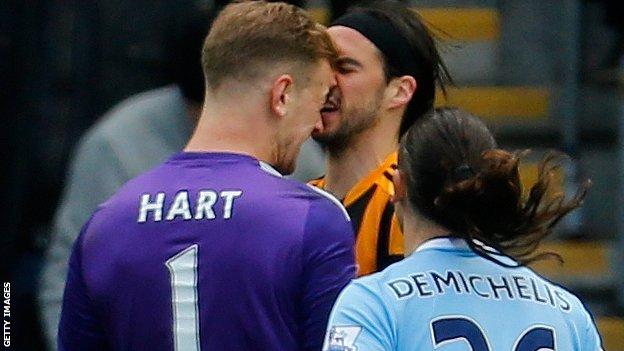 Manchester City keeper Joe Hart (left) and Hull City striker George Boyd clash during the game between their sides