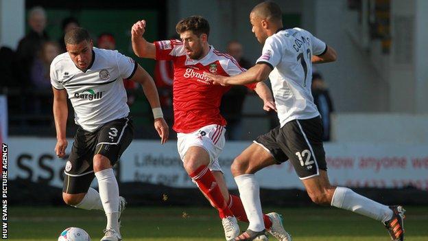 Mark Carrington of Wrexham challenges Chris Bush and Dominic Collins of Hereford United