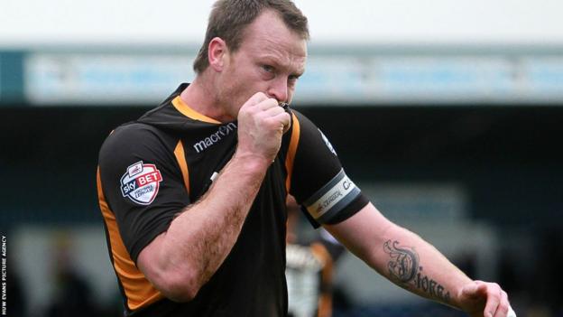 Midfielder Michael Flynn kisses the Newport County badge following his side's 1-0 win at Torquay United.