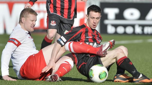 Ards defender David Armstrong and Paul Heatley of Crusaders battle for the ball in the match at Seaview
