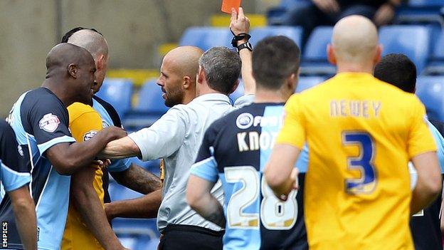 Wycombe players engage with the referee