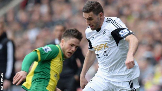 Swansea's Angel Rangel battles for the ball with a Norwich City defender