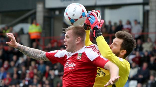 Wrexham striker Andy Bishop and Macclesfield's former Wales Under-21 keeper Rhys Taylor go up for a high ball.
