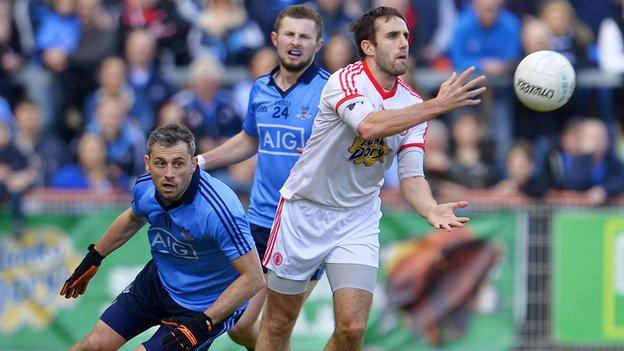 Mark Donnelly gets the ball away despite Alan Brogan's attentions