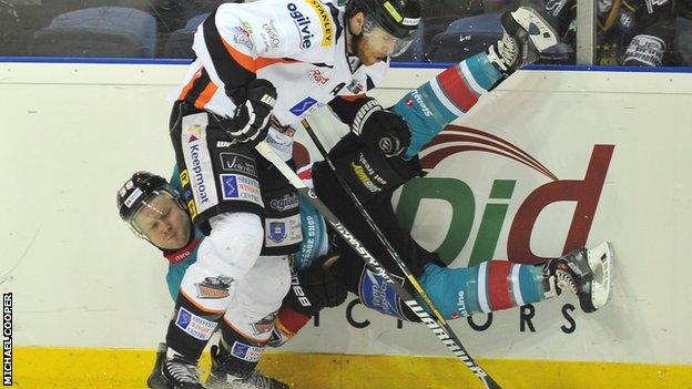 Belfast Giants player Gareth Roberts takes a tumble from Gord Baldwin's challenge in the play-off final
