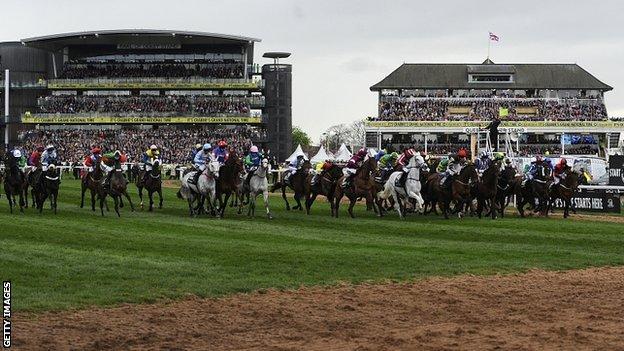 The starter waves his flag to signal a false start in the Grand National