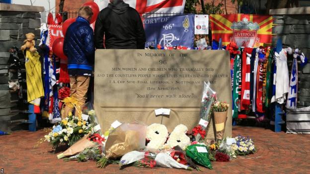 Fans gather before kick off to pay their respects at the memorial behind the Leppings Lane stand at Hillsborough to the 96 fans who died