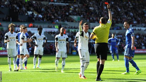 Swansea's Pablo Hernandez of Swansea remonstrates with Referee Phil Dowd as he shows the red card to Chico Flores (left) after 16 minutes