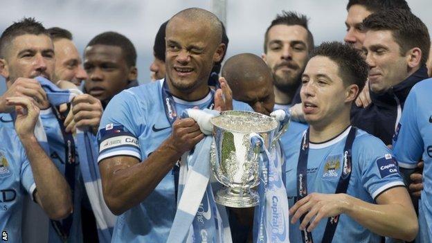 Manchester City players, including captain Vincent Kompany (holding trophy)