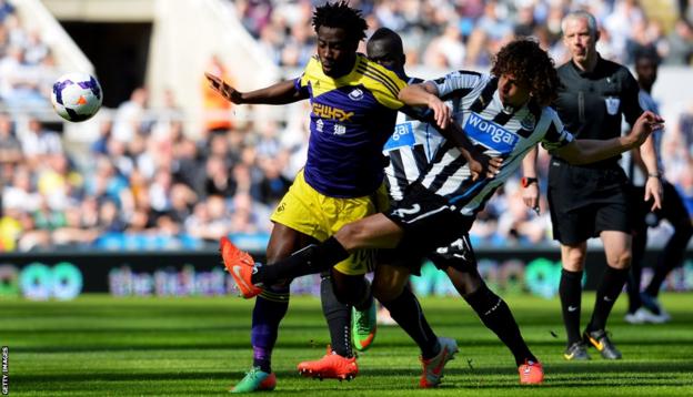 Wilfried Bony of Swansea City is tackled by Fabrizio Coloccini of Newcastle United