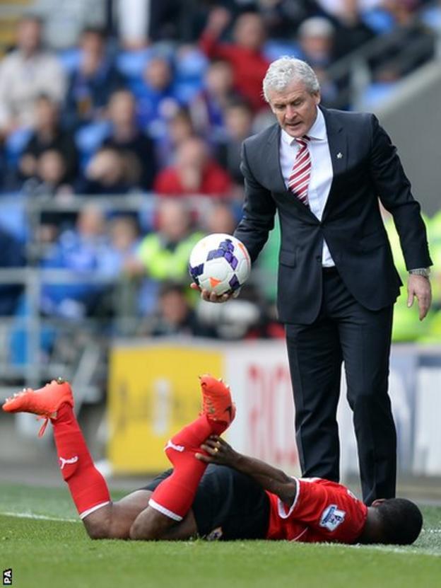 Stoke City manager Mark Hughes looks down at Cardiff's Kevin Theophile Catherine after he was tackled by Stoke City"s Glenn Whelan