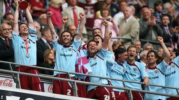 Burnley's Steven Caldwell (left) celebrates with the trophy and his team mates after gaining promotion into the Premier League in 2009