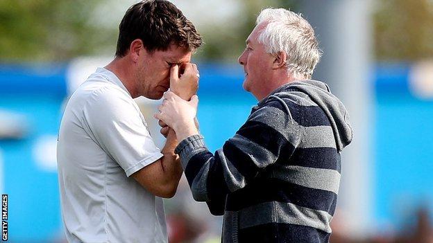 Bristol Rovers manager Darrell Clarke comforted by a fan