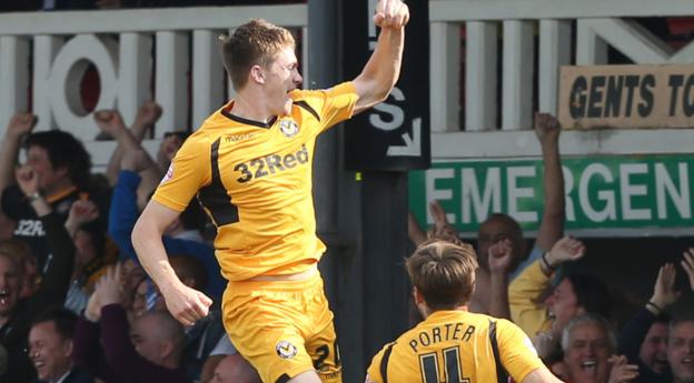 Kevin Feely jumps high to celebrate his late winning goal for Newport County against Rochdale at Rodney Parade