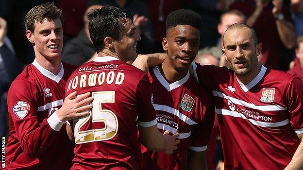 Northampton Town players celebrate scoring against Oxford United