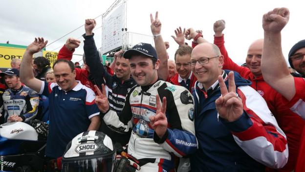 Michael Dunlop celebrates with his team after winning the feature Superbike race following a Superstock victory earlier in the day