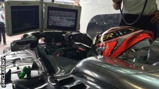 McLaren's Kevin Magnussen watches the TV while the team waits for the Monaco track to dry in free practice.