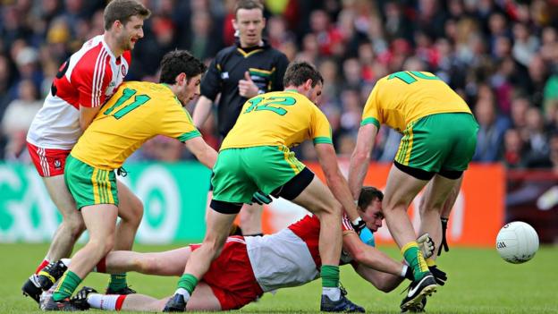 Derry's Patsy Bradley hits the deck as Donegal opponents Ryan McHugh, Odhran MacNiallais and Christy Toye attempt to win possession