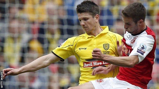 Shane Cansdell-Sherriff (left) tussles with Fleetwood Town's Matty Blair during the League Two play-of final