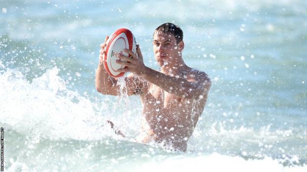 Liam Williams and the Welsh players hold a recovery session in the sea.