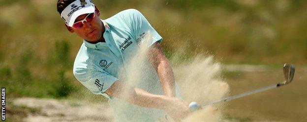 Ian Poulter plays out of a sandy lie during practice for the US Open