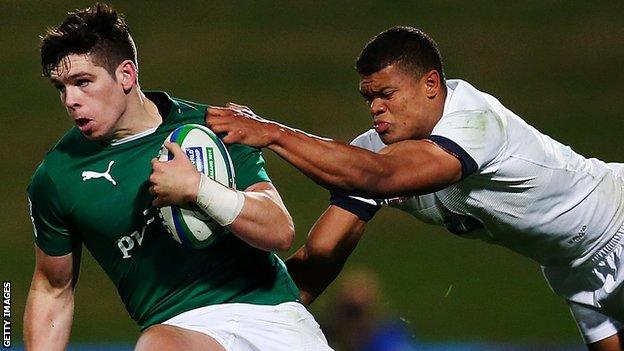Alex Wootton of Ireland is tackled by Nathan Earle of England