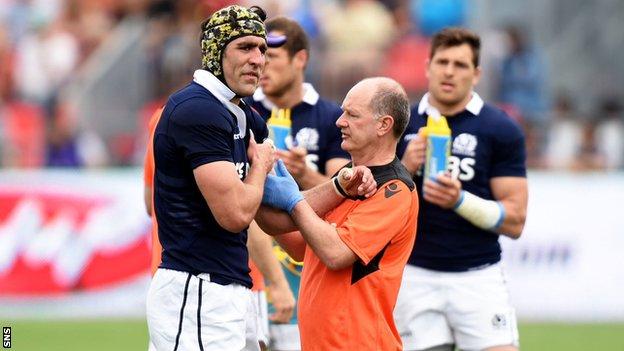 Scotland forward Kelly Brown is treated by team doctor