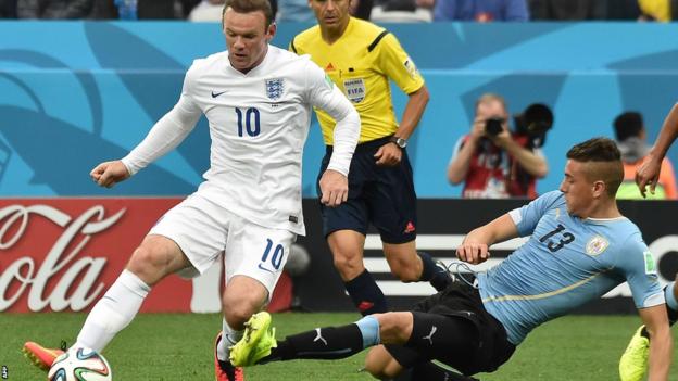 England's Wayne Rooney is challenged by Uruguay's Jose Maria Gimenez