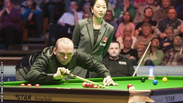 Stuart Bingham pots as match referee Zhu Ying watches